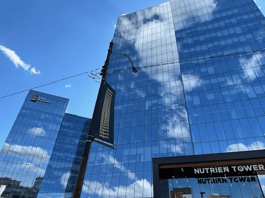 A building with many windows and clouds reflected in it.